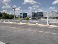 the empty roadway is full of bicycles, with buildings in the background and cars parked along the side