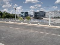 the empty roadway is full of bicycles, with buildings in the background and cars parked along the side