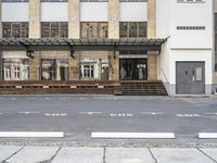 an empty building with signs on the street and people on bikes in traffic passing by