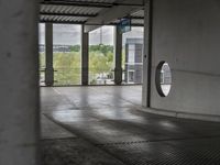 a view through a window at an outdoor area with concrete walls and ceilinging in the background