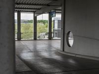 a view through a window at an outdoor area with concrete walls and ceilinging in the background