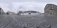 this is a 360 - view of a bricked area with two tall buildings in the background