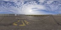 a fish eye lens of a runway with an airplane coming into view from it and behind