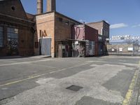 a brick building with graffiti written on it and a fence surrounding the building and building