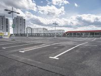 an empty parking lot with a number one across from it, and some buildings in the background