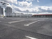 an empty parking lot with a number one across from it, and some buildings in the background