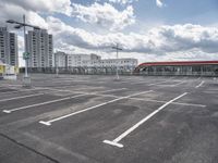 an empty parking lot with a number one across from it, and some buildings in the background