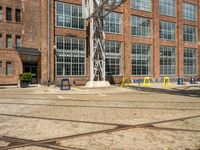 a bunch of yellow chairs sitting in front of a building that has a metal structure on it's side