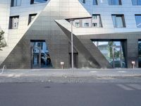 there is a large triangle shaped building that appears to be an inverted structure on a street corner