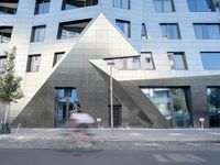 there is a large triangle shaped building that appears to be an inverted structure on a street corner