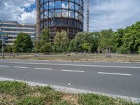 there is an empty street in front of a huge building under construction with trees around