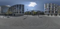 a view of a circle that is reflecting the buildings below it and a person on a skateboard