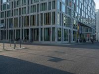 many buildings in the middle of a city with pedestrians walking and parked bikes on the street