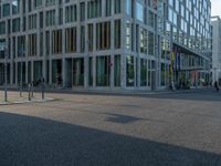 many buildings in the middle of a city with pedestrians walking and parked bikes on the street