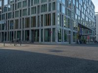 many buildings in the middle of a city with pedestrians walking and parked bikes on the street