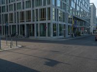 many buildings in the middle of a city with pedestrians walking and parked bikes on the street