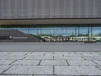 the empty lot outside of an airport with its reflection in glass walls and stairs coming up through it