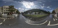 a fish eye view of an urban street with a bridge overpassing over a city street