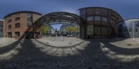 the reflection of some buildings in the glass dome, in a city square with cobblestones