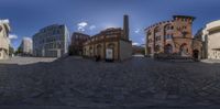 the sun shines on a cobble - stone street, as seen from a fisheye lens