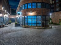 some dark blue windows in an industrial building with no one on the street to the right