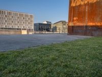 this grass field has been cut short to cover the area in the distance, and it is a grassy area next to an old building