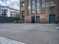 the outside of a warehouse with two tables and a bench outside of the building with a view