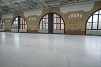 a large warehouse building has an open floor plan with windows and concrete floors, along with brickwork on the walls