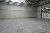 an empty warehouse with concrete floors and overhead lights in it to help get more daylight