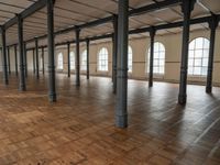 a large open room with wooden flooring and exposed ceilings in it is clean, well lit and ready to be used as an office