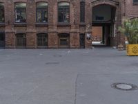 an entrance to a warehouse with a yellow planter outside and a building behind it