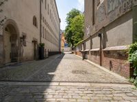 two men walk along the cobblestone streets outside an old - fashioned building in berlin