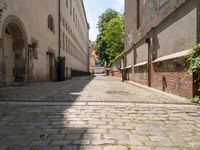 two men walk along the cobblestone streets outside an old - fashioned building in berlin