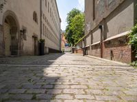 two men walk along the cobblestone streets outside an old - fashioned building in berlin