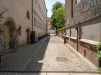 two men walk along the cobblestone streets outside an old - fashioned building in berlin