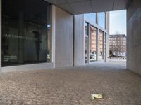 a piece of tape lies on the floor outside a large building with a clock and the door