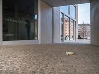 a piece of tape lies on the floor outside a large building with a clock and the door