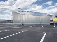 parking spaces with white lines and big domed building in distance on a cloudy day with fluffy clouds overhead