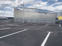 parking spaces with white lines and big domed building in distance on a cloudy day with fluffy clouds overhead