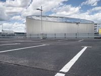 parking spaces with white lines and big domed building in distance on a cloudy day with fluffy clouds overhead