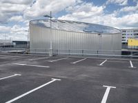 parking spaces with white lines and big domed building in distance on a cloudy day with fluffy clouds overhead