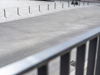 an image of a man riding a motorcycle on the side of the street in a parking lot