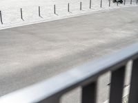 an image of a man riding a motorcycle on the side of the street in a parking lot