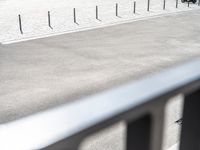 an image of a man riding a motorcycle on the side of the street in a parking lot