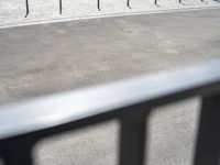 an image of a man riding a motorcycle on the side of the street in a parking lot