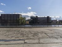 an empty parking lot with many building and boats near it on a sunny day on the water