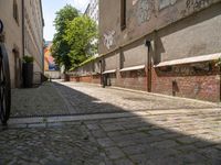 bicycles are parked at the edge of a cobblestoneed pathway in front of an apartment building