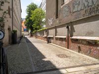 bicycles are parked at the edge of a cobblestoneed pathway in front of an apartment building