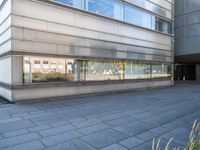 the sidewalk outside the building is gray and there is also some grass in front of the building