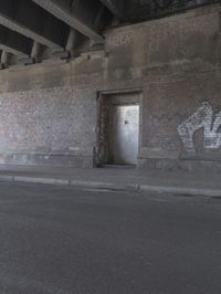 a view inside of a building with graffiti on the walls and sidewalk area below it